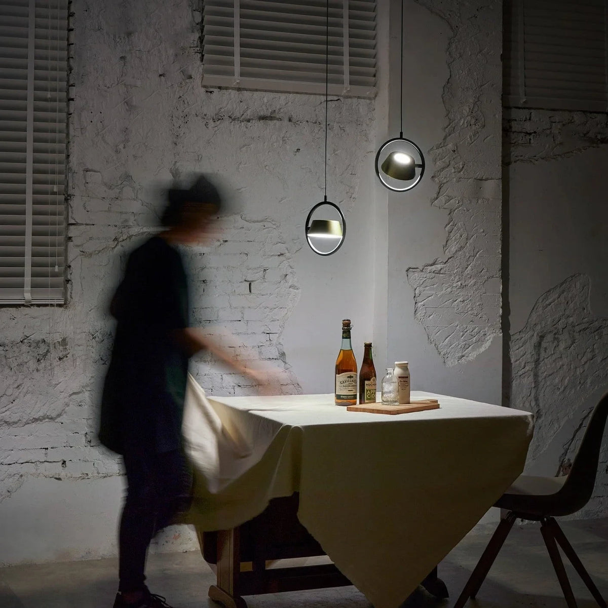 Tilting shade LED pendant in ring frame, above a dining table