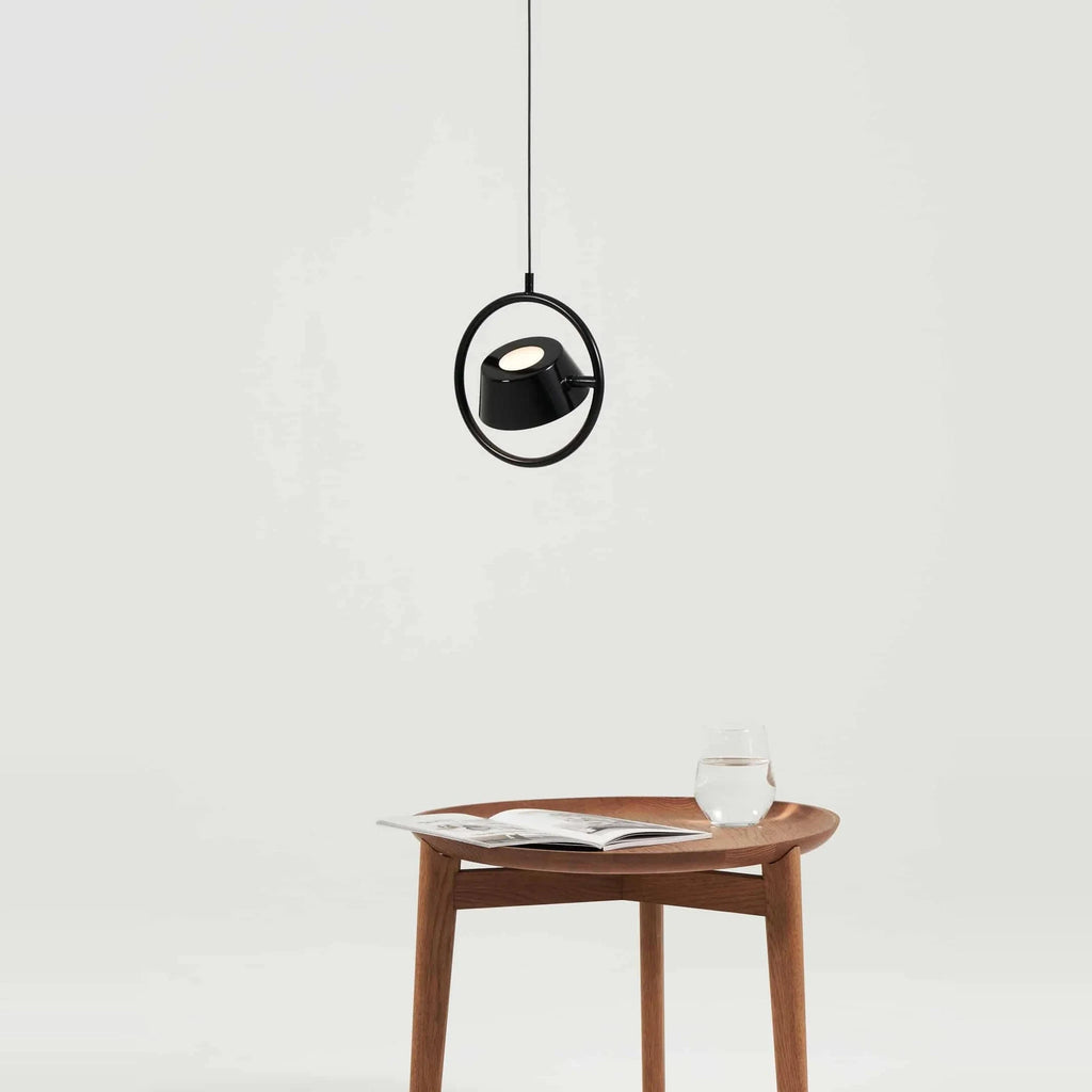 Tilting shade LED pendant in ring frame, above a side table