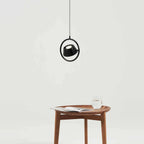 Tilting shade LED pendant in ring frame, above a side table