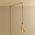 Plug-in pendant with large tinted teardrop bulb, graphite, lit, hung from a wall node