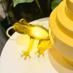 Translucent frog table lamp, in yellow on a cake stand