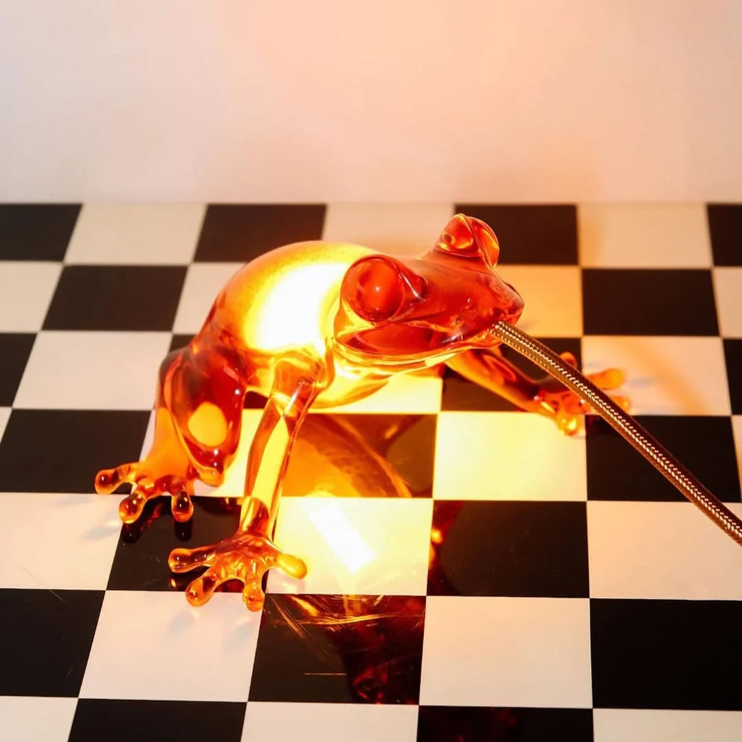 Translucent frog table lamp, in amber on a chequered floor