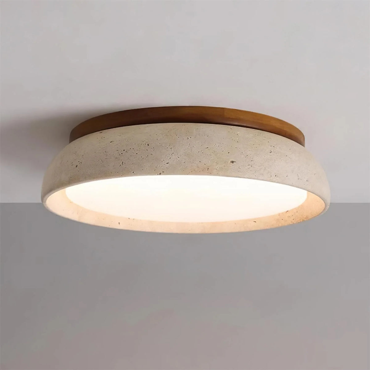 Travertine and wood flush ceiling light, lit on a ceiling