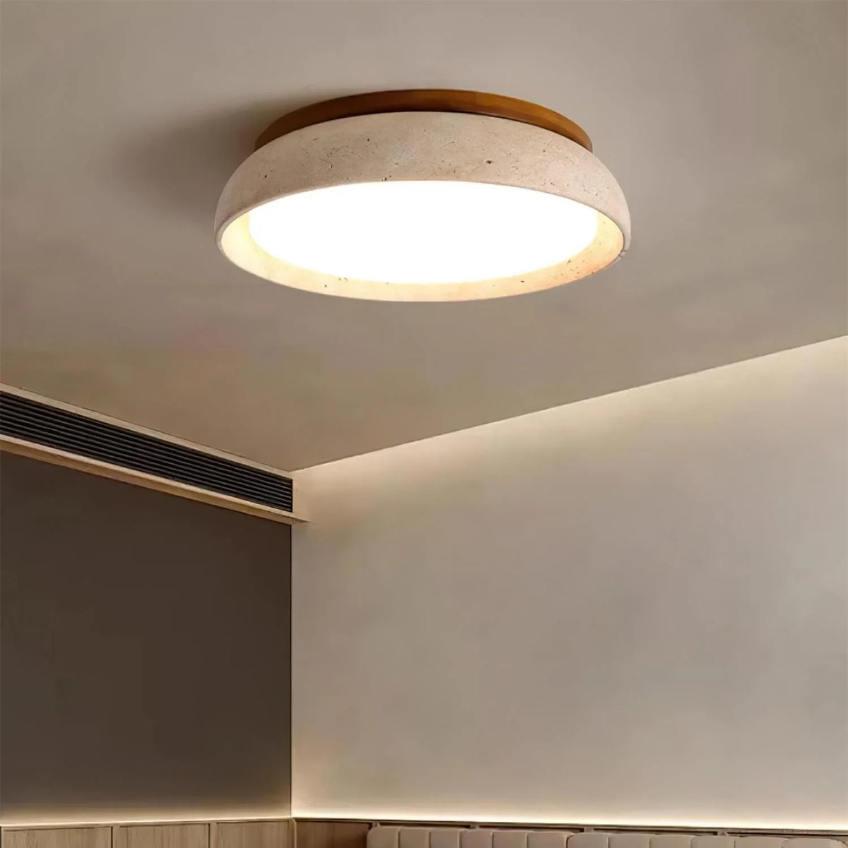 Travertine and wood flush ceiling light, lit on a ceiling