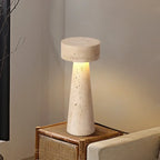 Travertine table lamp on a rattan side table next to a sofa