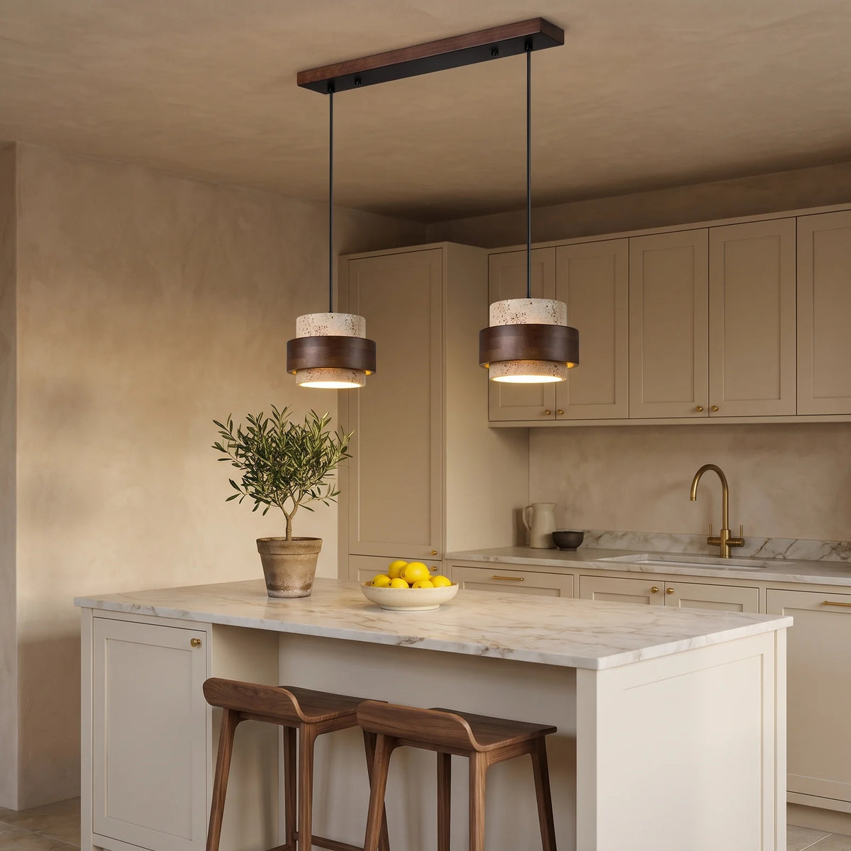 Two beige travertine and walnut drum pendants over a kitchen island