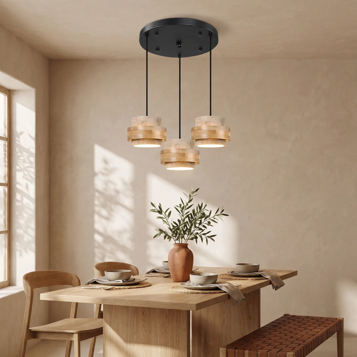 Three natural travertine and oak drum pendants on a round canopy over a dining table