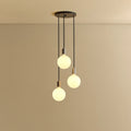 Triple Opal Sphere Cluster Pendant, in graphite, lit, against a plain wall