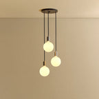 Triple Opal Sphere Cluster Pendant, in graphite, lit, against a plain wall