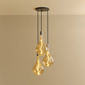 Triple Tall Tinted Bulb Cluster Pendant, in graphite, lit, against a plain wall