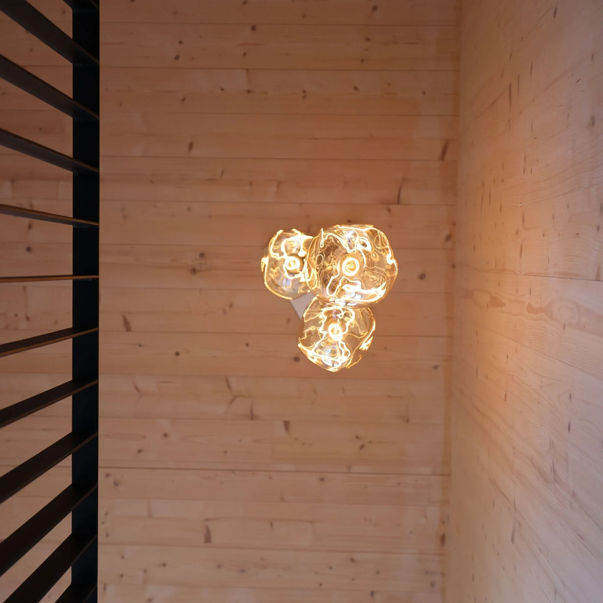 Triple Tall Tinted Bulb Cluster Pendant, close-up of a tinted glass bulb lit