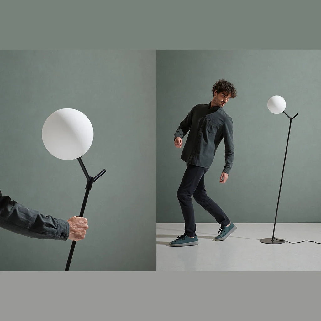 Twig branch floor lamp with opal glass globe, with a person beside it