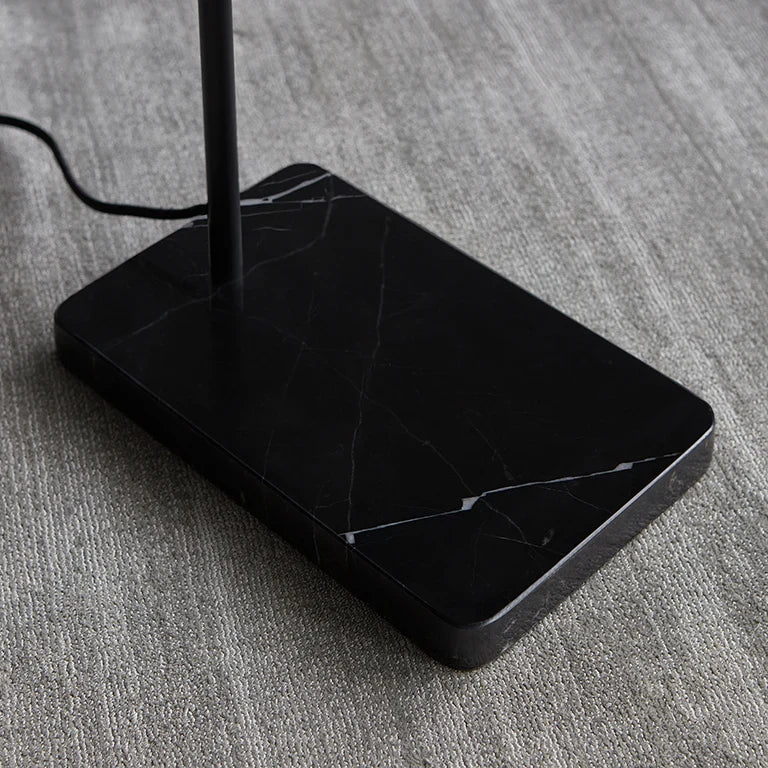 Twin-head adjustable floor lamp with a marble base, close-up of the black marble base