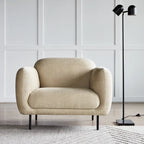 Twin-head adjustable floor lamp with a marble base, in black beside an armchair