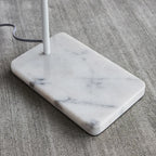 Twin-head adjustable floor lamp with a marble base, close-up of the white marble base
