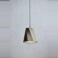 Twisted concrete pendant, against a concrete wall