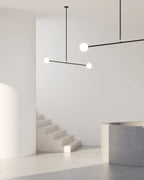 Two-globe pendant with horizontal arm, in a pale stairwell