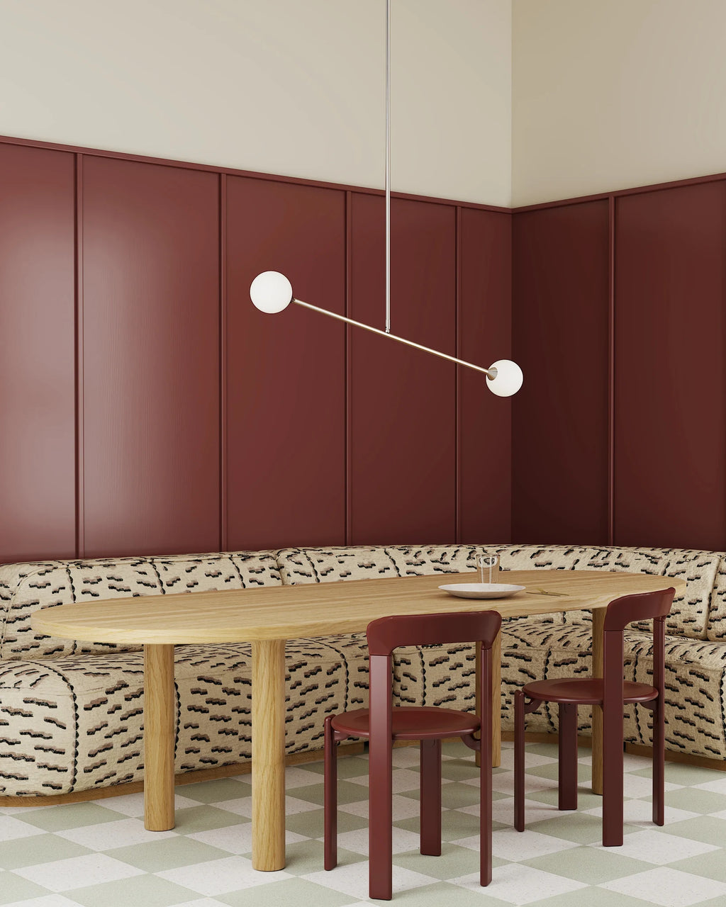 Two-globe pendant with horizontal arm, in white, above a dining table