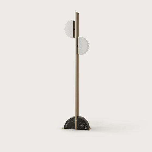 Aged gold column floor lamp with two scalloped opal shades, on a half-round black marble base, against a plain wall