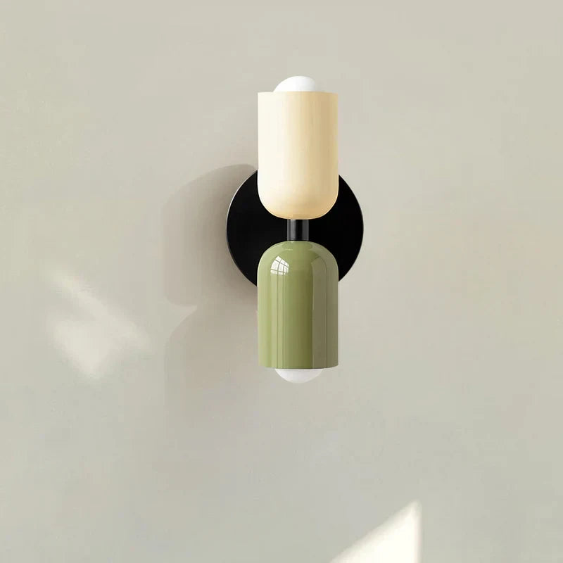 Two-tone up and down wall light, in beige and green near a plant