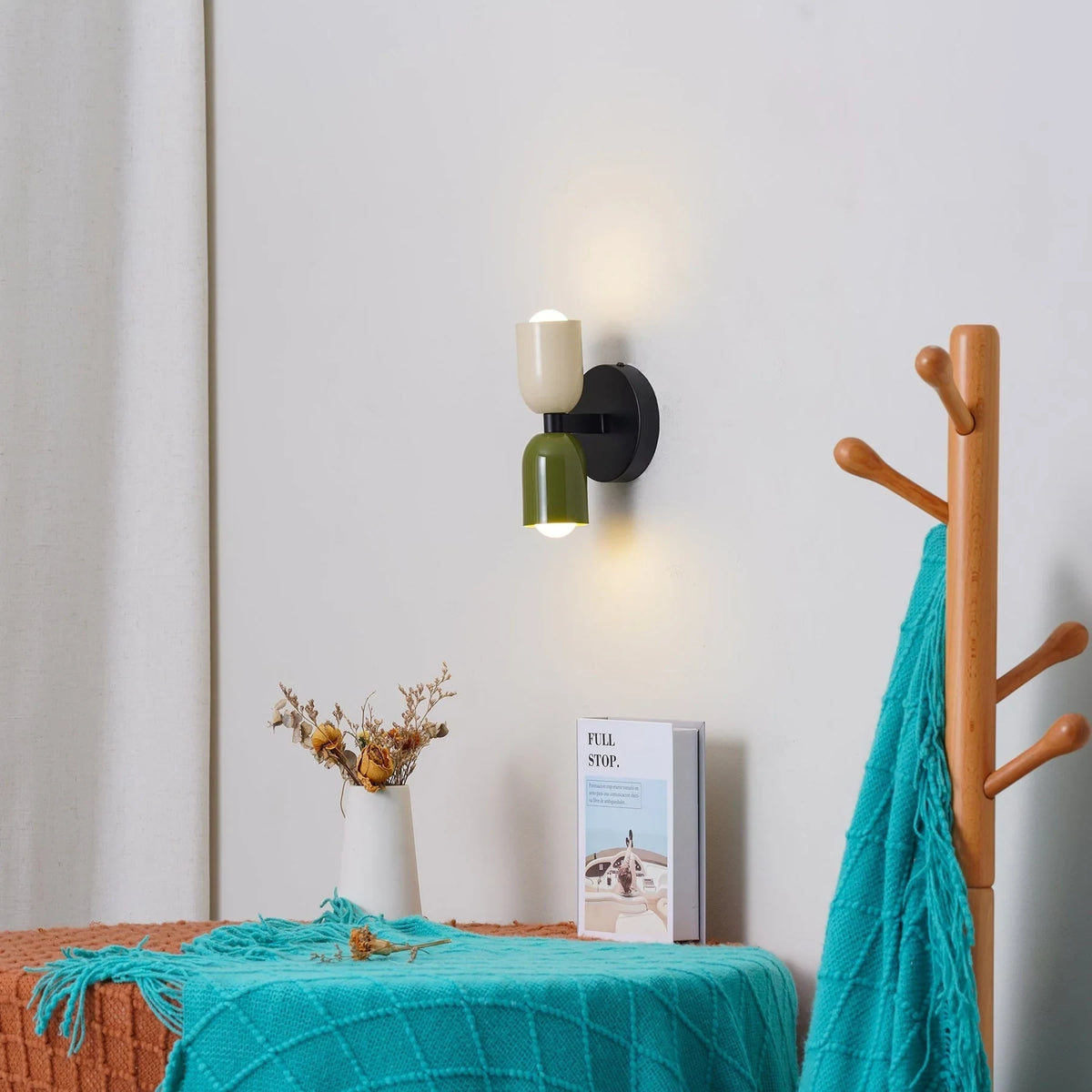 Two-tone up and down wall light, in beige and black by a coat stand