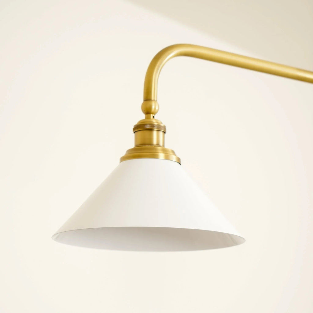 Two-light gold bar pendant with white cone shades, in a room