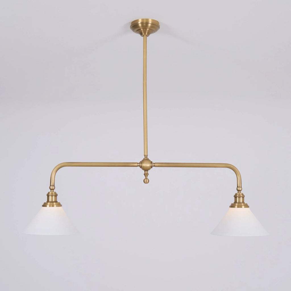 Two-light gold bar pendant with white cone shades, in a room