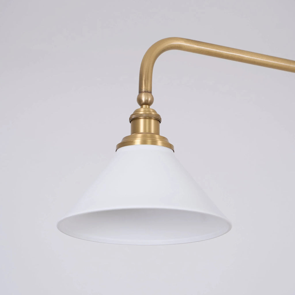 Two-light gold bar pendant with white cone shades, close-up of a shade