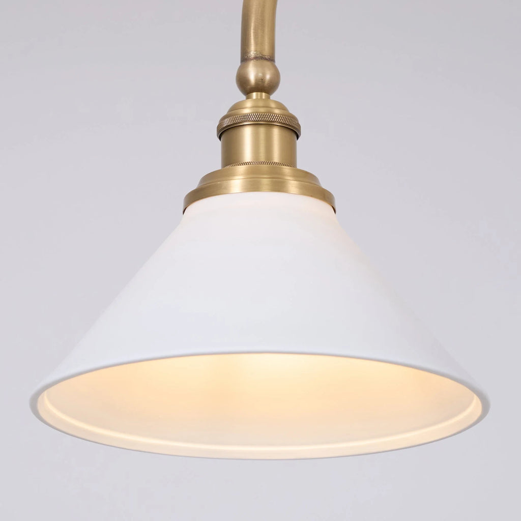 Two-light gold bar pendant with white cone shades, close-up of a shade