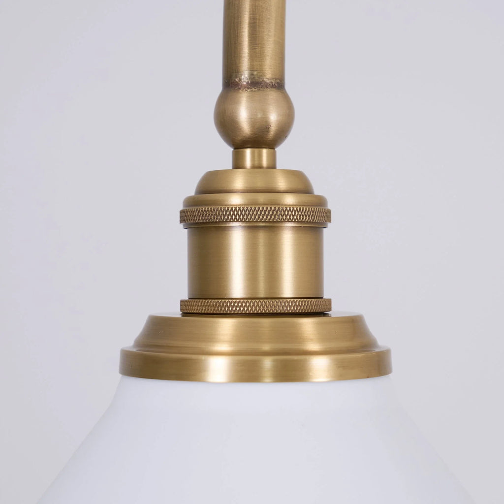 Two-light gold bar pendant with white cone shades, close-up of the fitting