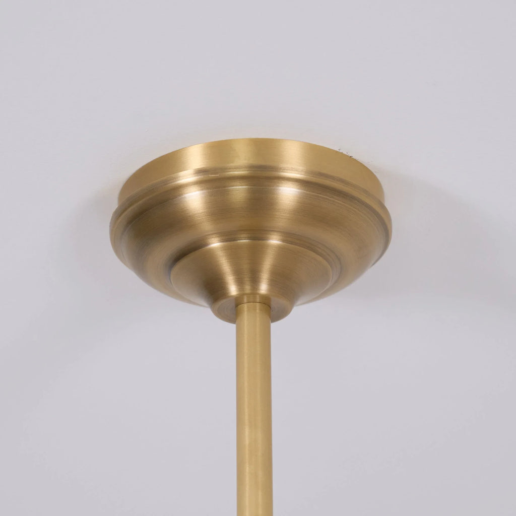 Two-light gold bar pendant with white cone shades, close-up of the ceiling plate