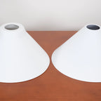 Two-light gold bar pendant with white cone shades, spare shades on a sideboard