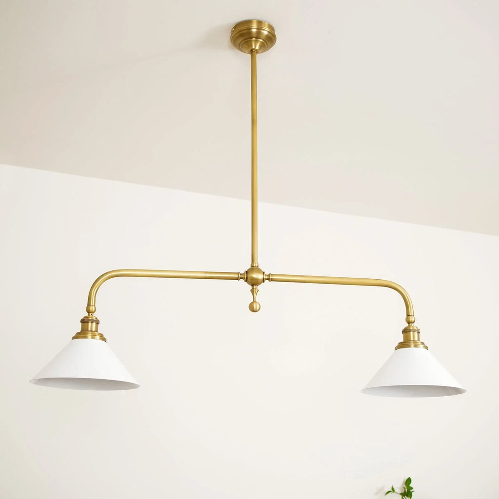 Two-light gold bar pendant with white cone shades, in a room