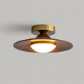 Low profile walnut and gold flush ceiling light, lit, from below