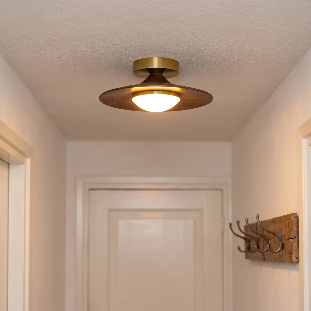Low profile walnut and gold flush ceiling light, lit in a hallway