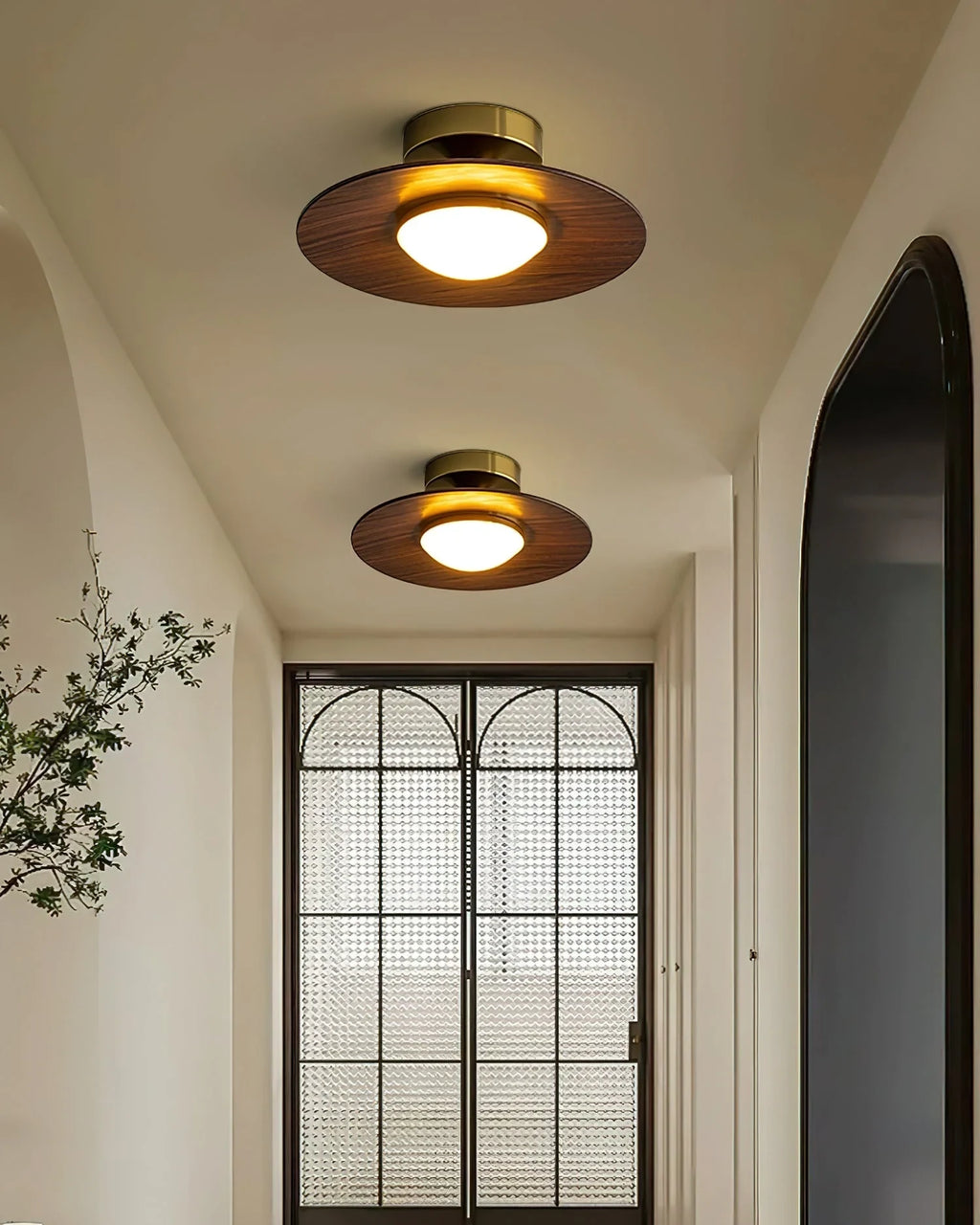Low profile walnut and gold flush ceiling light, two lit in an entrance hall