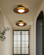 Low profile walnut and gold flush ceiling light, two lit in an entrance hall