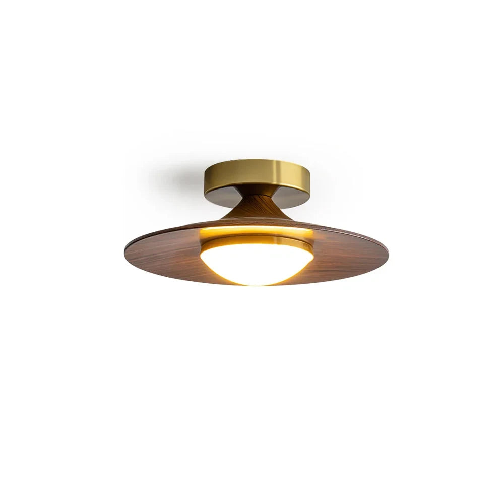 Low profile walnut and gold flush ceiling light, lit, on a white background