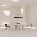 Walnut linear LED pendant, above a white dining table