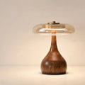 Walnut-tone timber table lamp with a tinted glass disc, Petite, lit