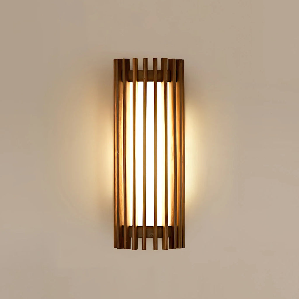 Walnut wood slatted wall light, lit on a plain wall