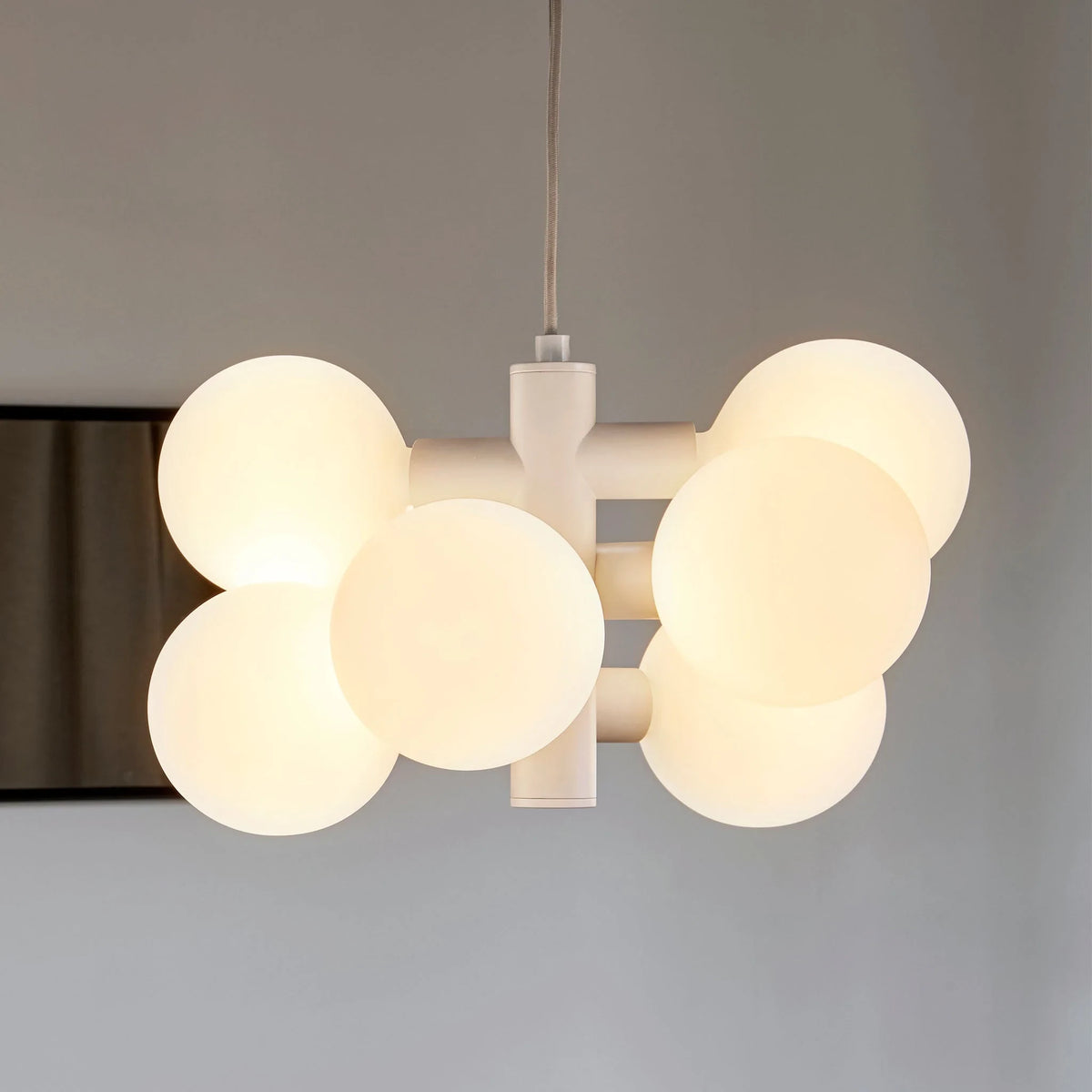 White steel globe cluster chandelier, close-up, lit