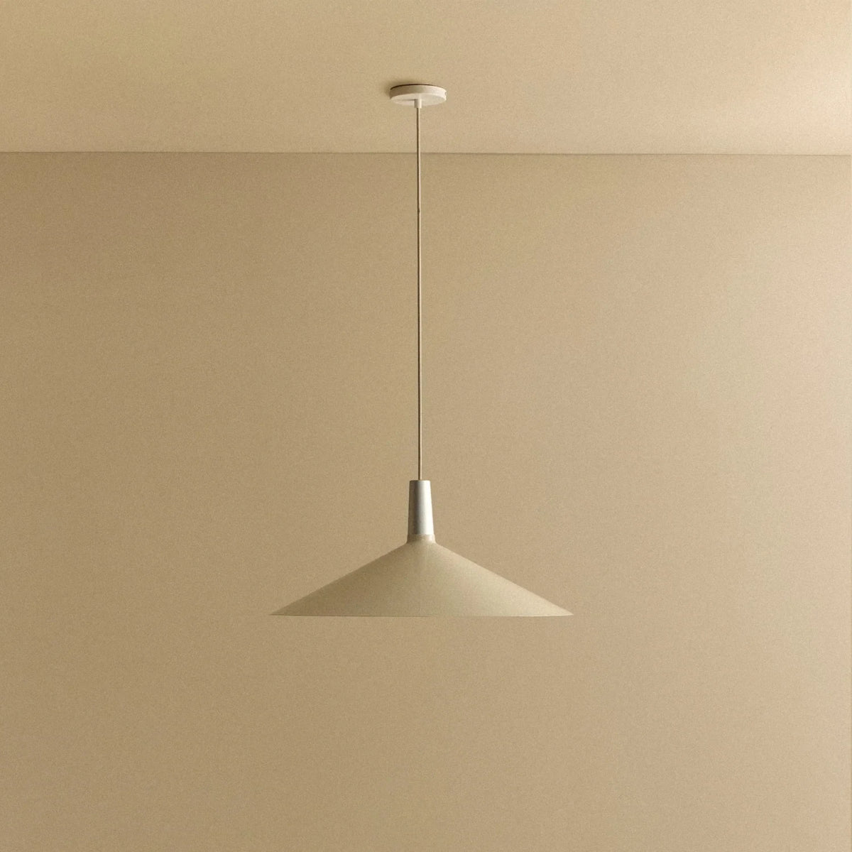 Large oyster white wide low-profile steel pendant, against a plain wall