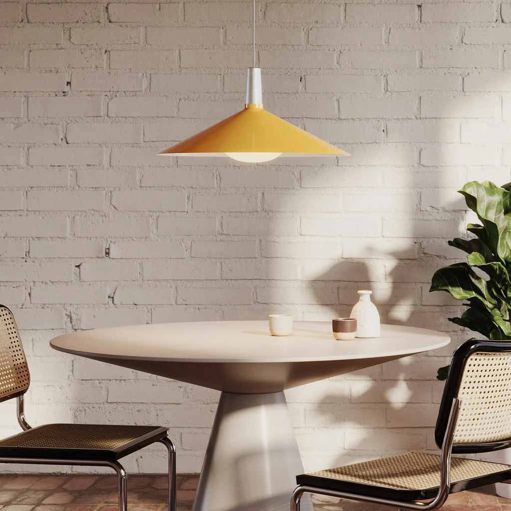 Large yellow wide steel pendant with oval bulb, above a dining table