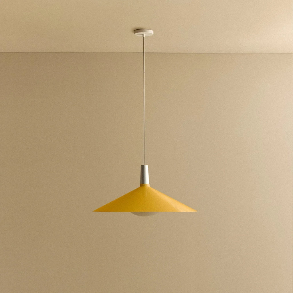 Large yellow wide steel pendant with oval bulb, against a plain wall, alternative view