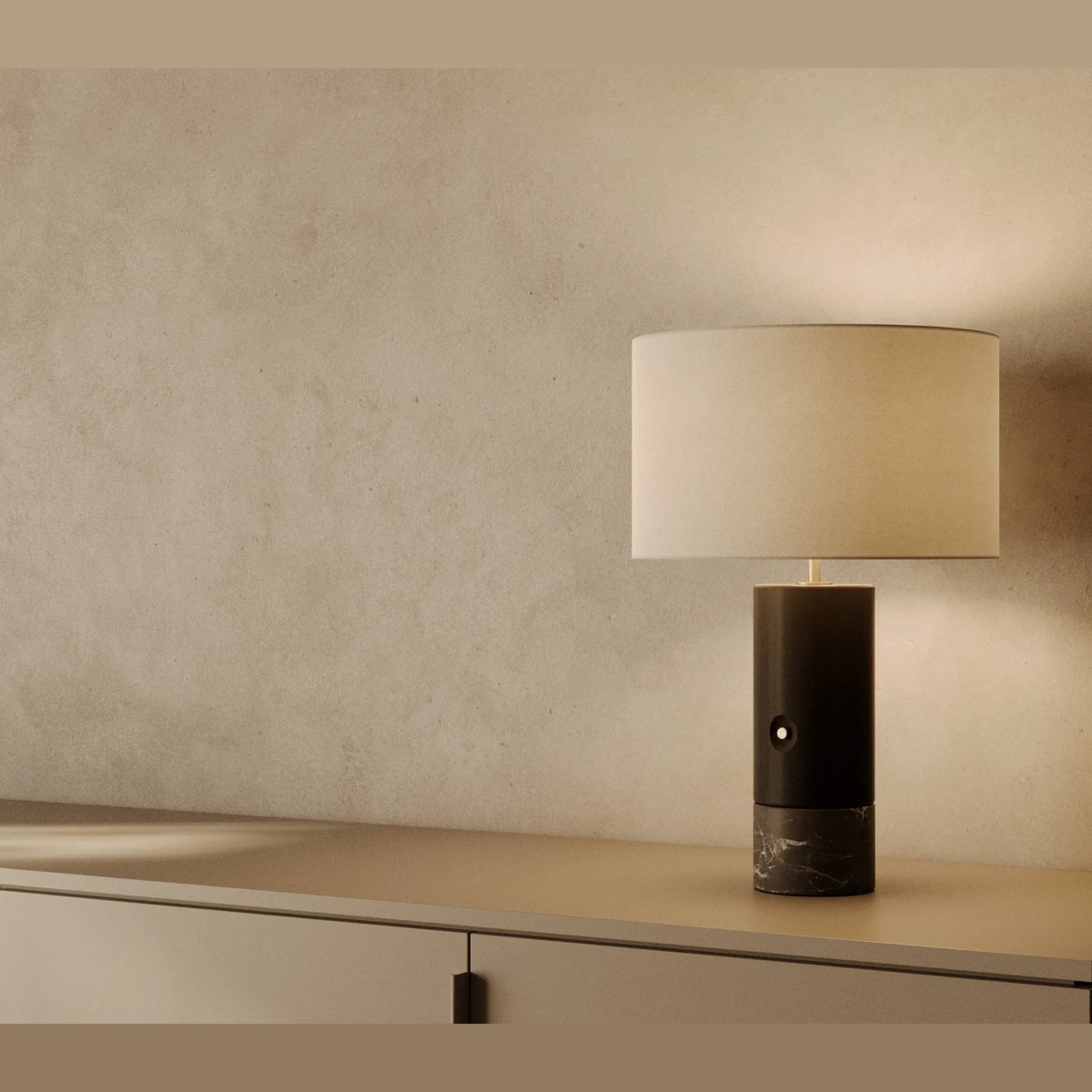 Wood and marble table lamp with drum shade, in black wood and black marble, on a shelf