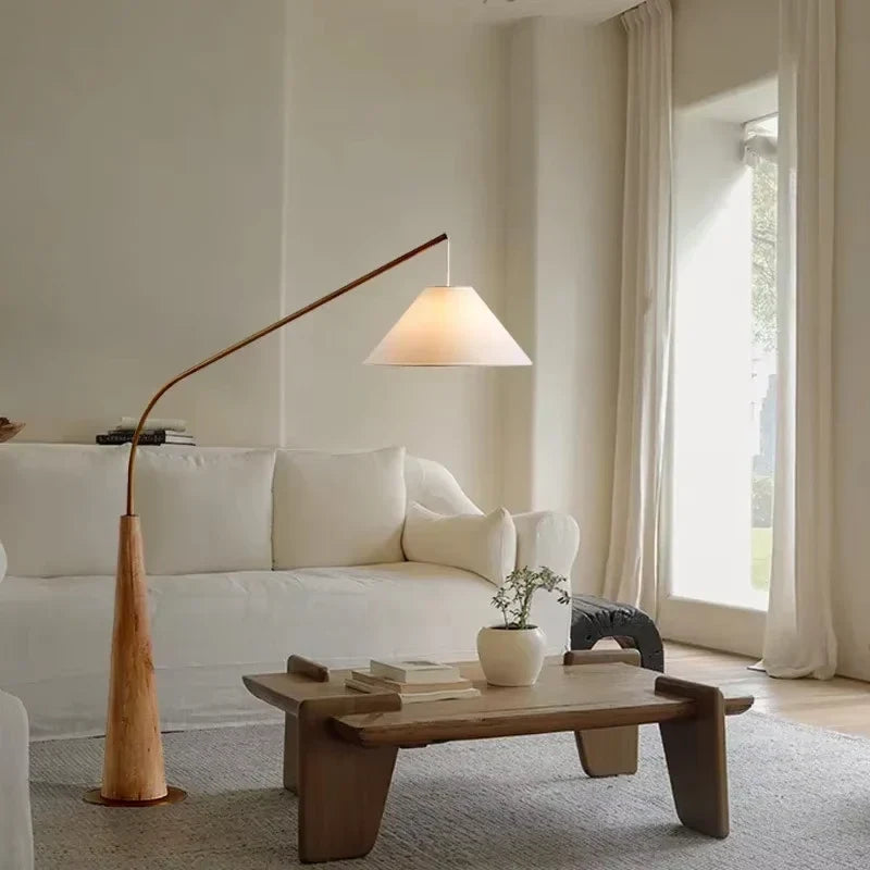 Wooden arc floor lamp, beside a cream sofa