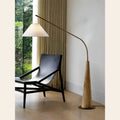 Wooden arc floor lamp, over a leather lounge chair
