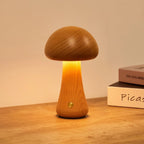 Wooden mushroom cordless table lamp, lit on a wooden table