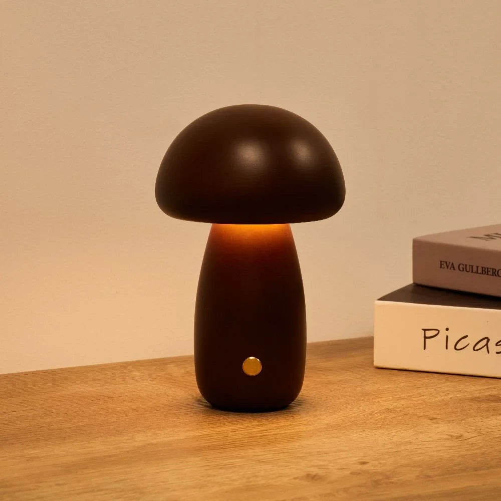 Wooden mushroom cordless table lamp, lit on a wooden table
